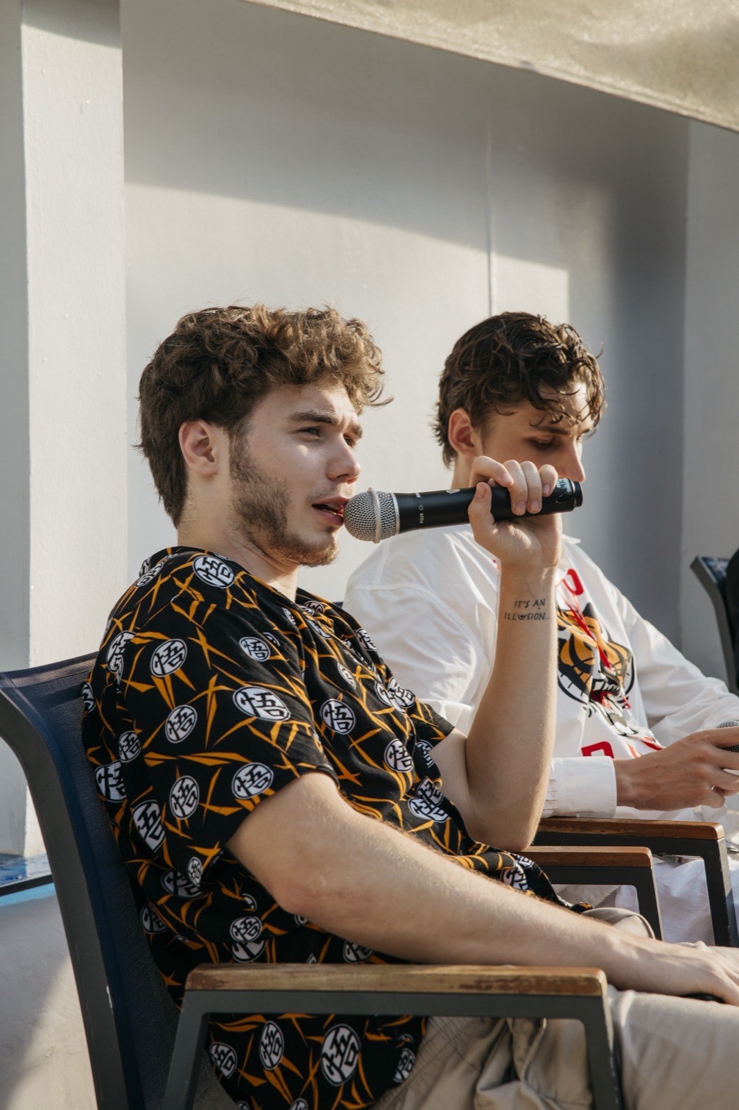 Vsevolod Gurkov speaking into a microphone next to a guest